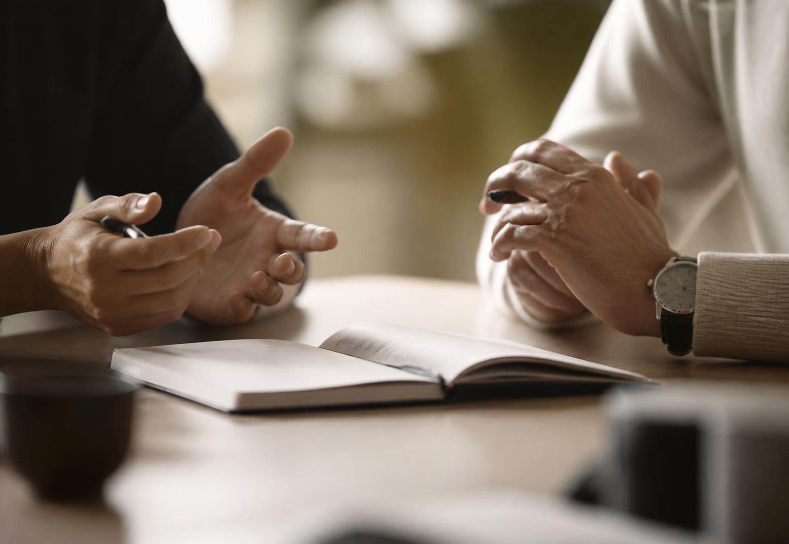 Due professionisti in conversazione attorno a un tavolo di lavoro